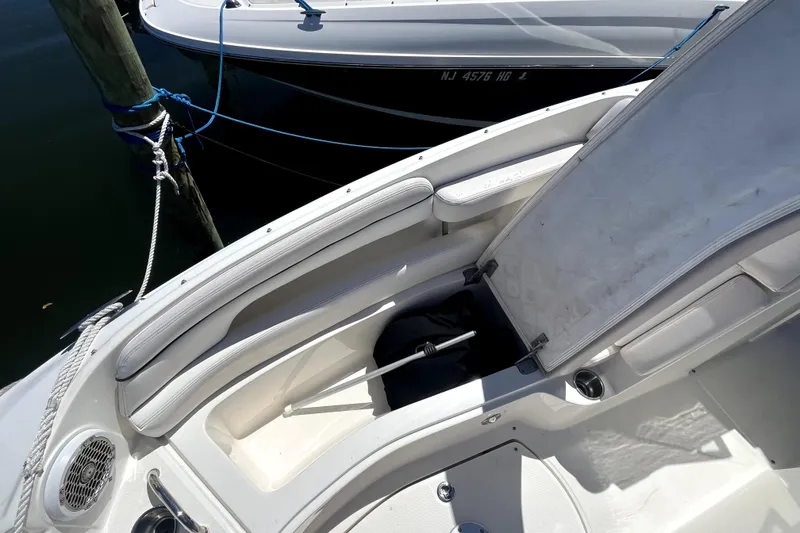 Slide: The Image of 2012 Sea Ray 260 Sundeck boat docked in a marina, featuring spacious seating. - 12