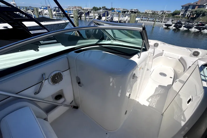 Slide: The Image of 2012 Sea Ray 260 Sundeck boat with spacious seating and canopy, docked at marina. - 18