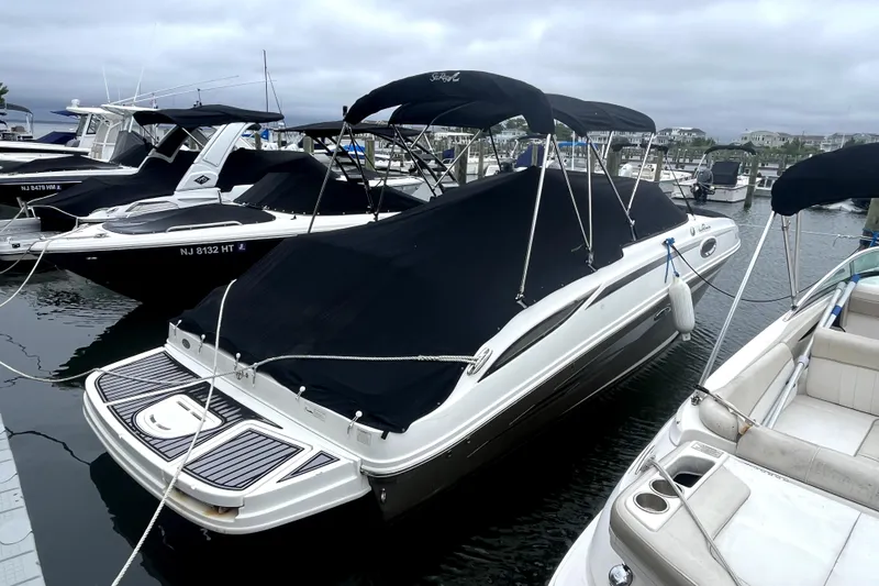 Slide: The Image of 2012 Sea Ray 260 Sundeck boat interior with white seating and dock view. - 27