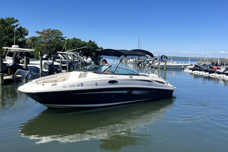 Slide: The Image of 2012 Sea Ray 260 Sundeck boat cruising in a marina under clear blue skies. - 3