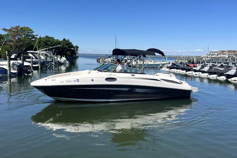 Slide: The Image of 2012 Sea Ray 260 Sundeck boat docked on a sunny day, surrounded by calm waters. - 4