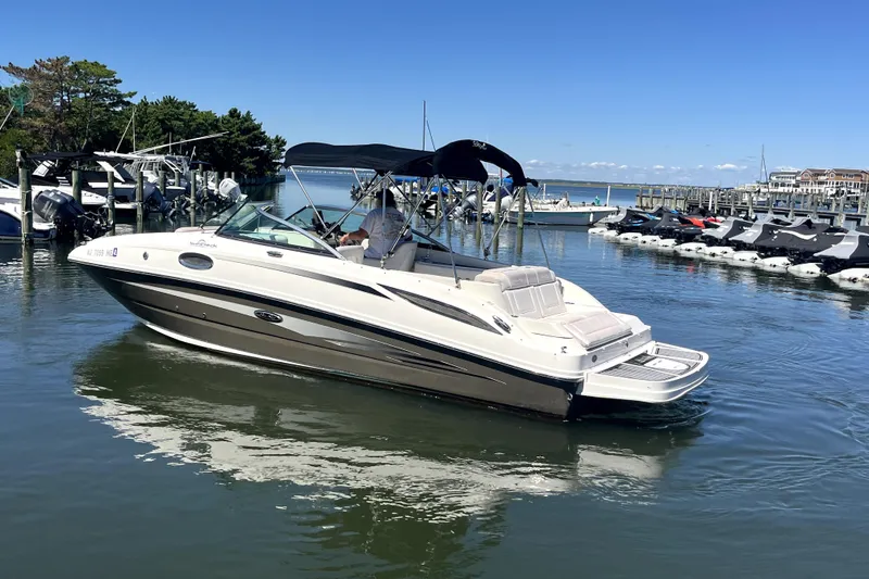 Slide: The Image of 2012 Sea Ray 260 Sundeck boat docked in a marina under clear blue skies. - 5