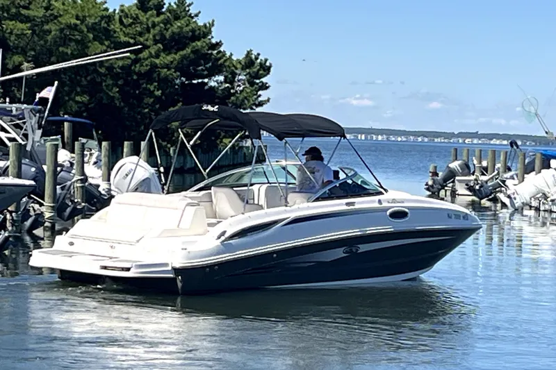 Slide: The Image of 2012 Sea Ray 260 Sundeck boat cruising near a marina with jet skis. - 7