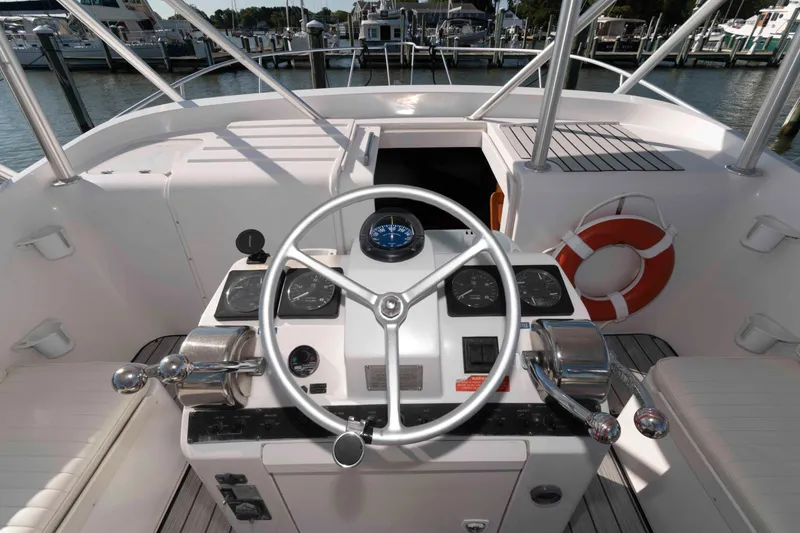 Slide: The Image of 1998 Luhrs 32 Open boat helm with steering wheel and control panel at marina. - 10