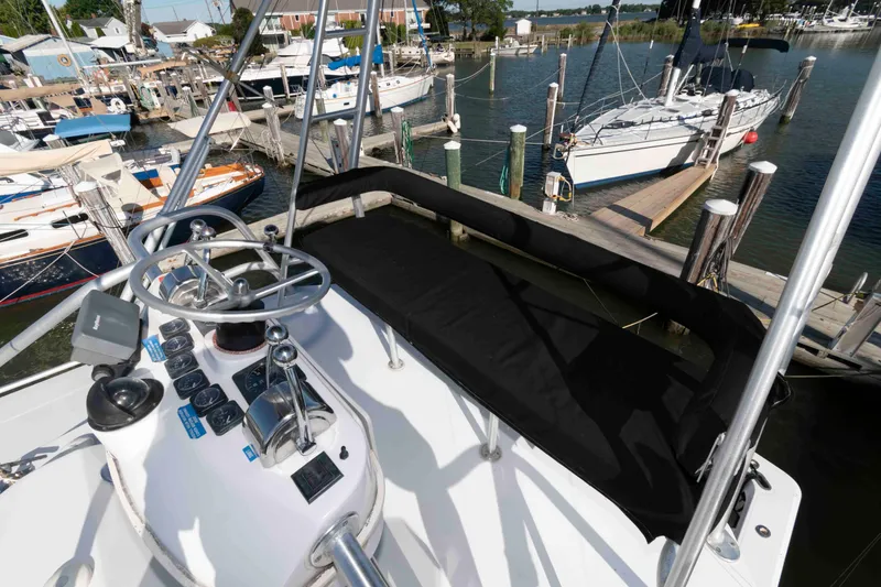 Slide: The Image of 1998 Luhrs 32 Open boat helm with marina view, featuring steering wheel and controls. - 15