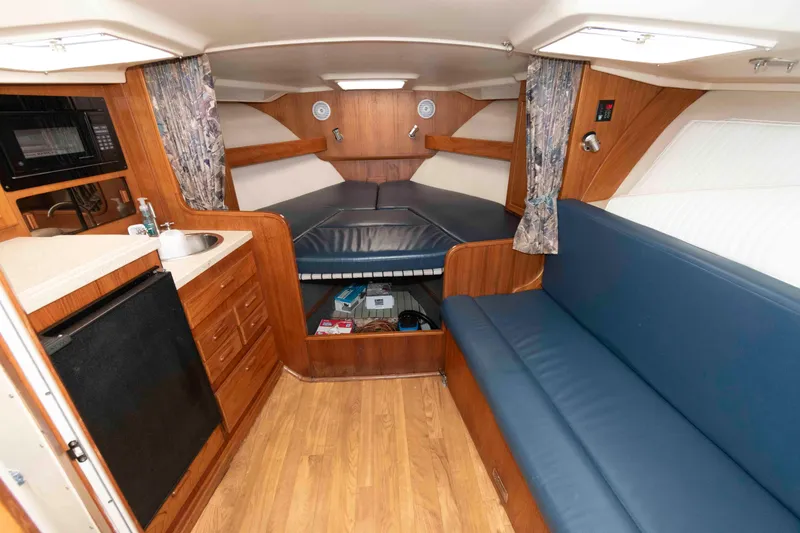 Slide: The Image of 1998 Luhrs 32 Open cabin interior with kitchenette, seating, and sleeping area. - 18