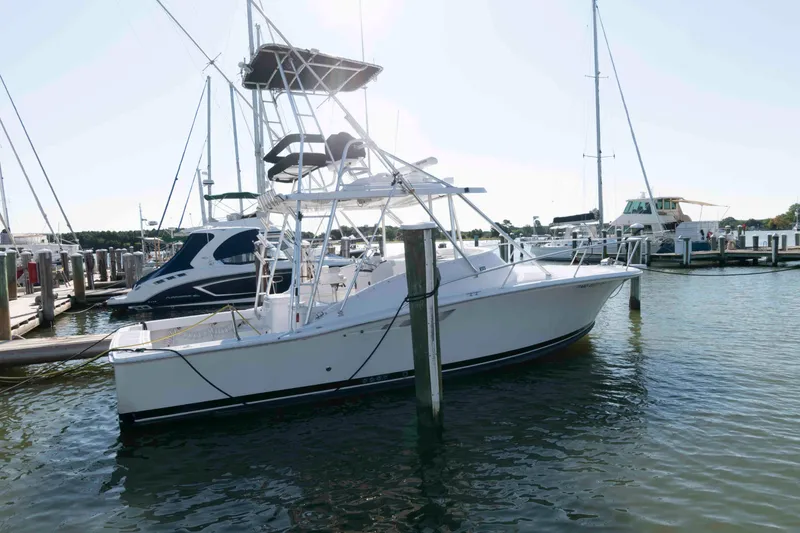 Slide: The Image of 1998 Luhrs 32 Open boat docked at a marina, featuring a sleek white design. - 2