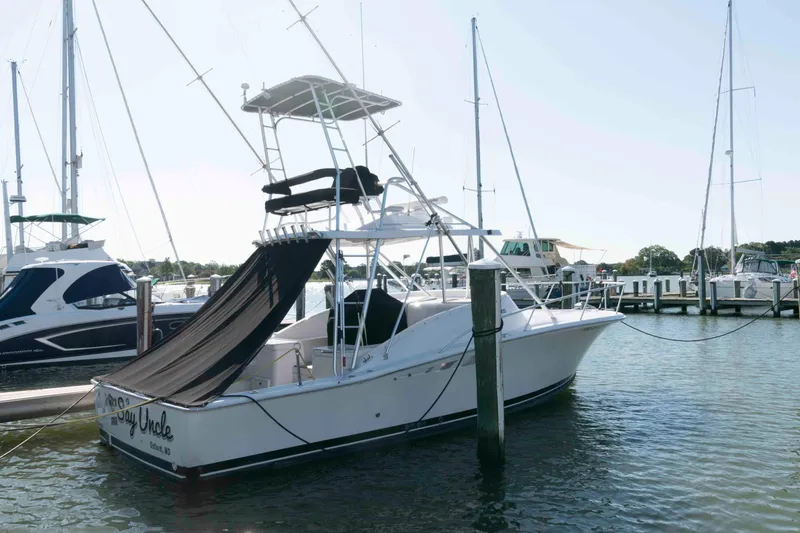 Slide: The Image of 1998 Luhrs 32 Open boat docked at marina, featuring a sleek design and fishing tower. - 3