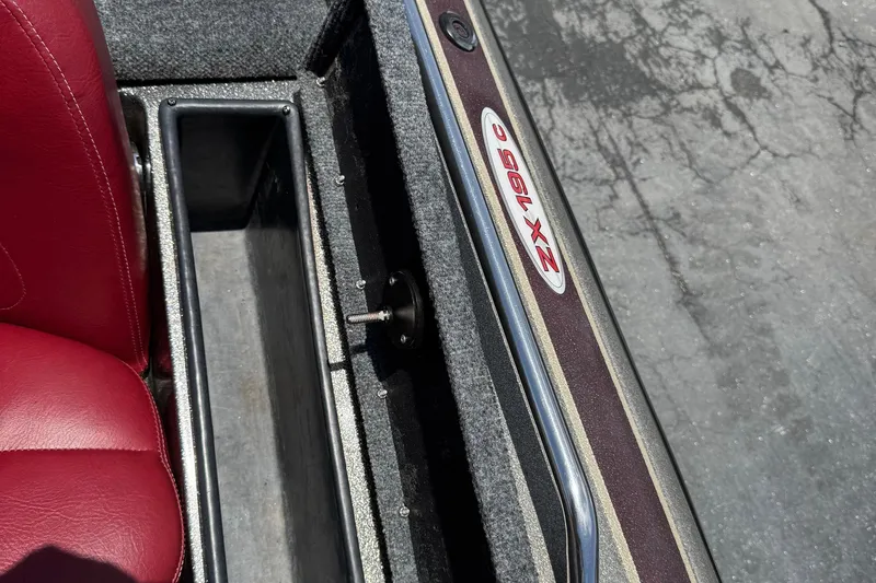 Slide: The Image of 1999 Skeeter ZX 195 boat interior with red seat and storage compartment. - 16