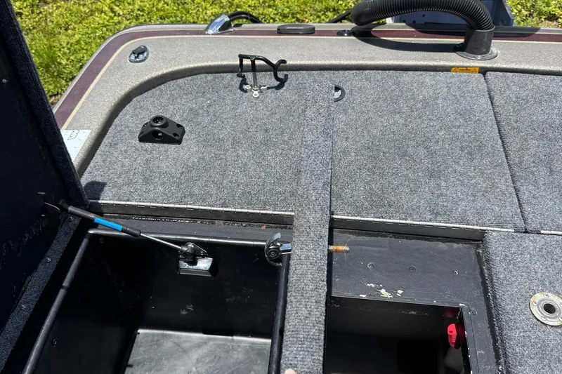 Slide: The Image of 1999 Skeeter ZX 195 boat interior with open storage compartment and carpeted deck. - 17