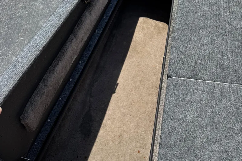 Slide: The Image of Open storage compartment in 1999 Skeeter ZX 195 boat, featuring gray carpeted interior. - 20
