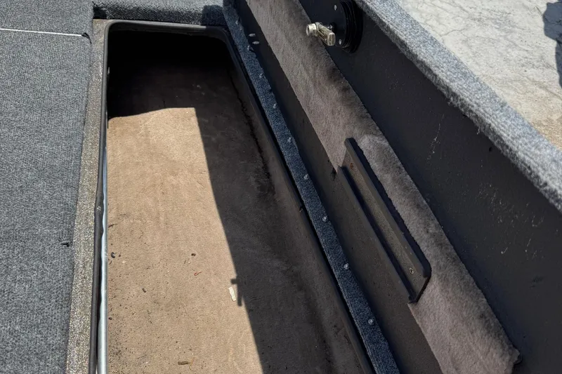 Slide: The Image of 1999 Skeeter ZX 195 boat storage compartment with carpeted interior and latch mechanism. - 21