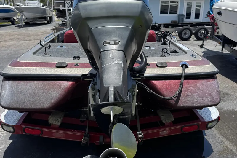 Slide: The Image of 1999 Skeeter ZX 195 boat with outboard motor, parked on a trailer in a marina. - 26