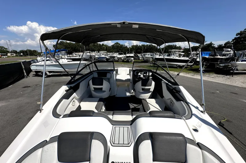 Slide: The Image of 2020 Yamaha Boats SX210 with canopy, parked in a marina under clear blue skies. - 11