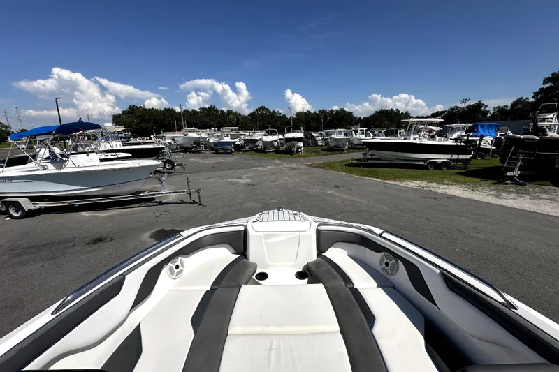 Slide: The Image of 2020 Yamaha Boats SX210 in a marina, surrounded by various boats under a clear sky. - 21