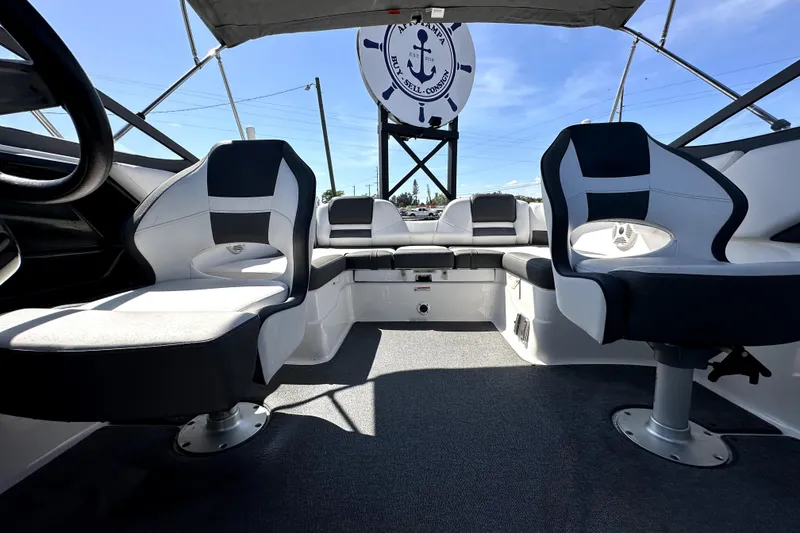 Slide: The Image of 2020 Yamaha Boats SX210 interior with modern seating and steering wheel under a clear sky. - 32