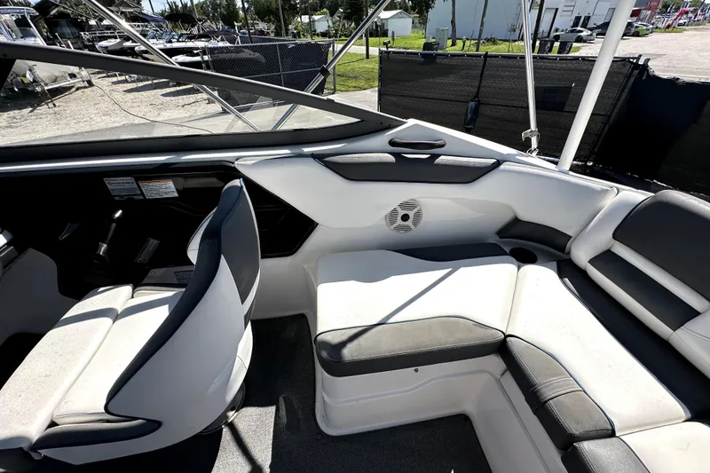 Slide: The Image of 2020 Yamaha Boats SX210 interior with white and gray seating, speaker, and steering area. - 35
