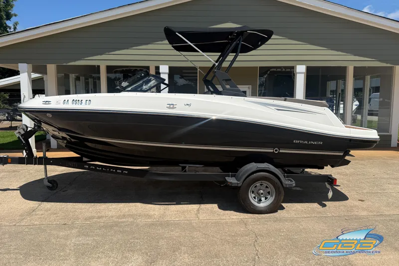 Slide: The Image of 2018 Bayliner VR5 Bowrider I/O boat on trailer, parked outside a building. - 0