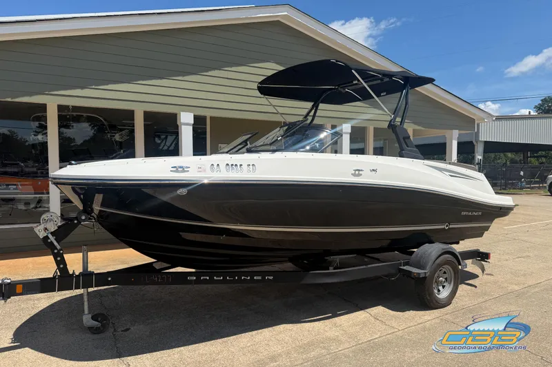 Slide: The Image of 2018 Bayliner VR5 Bowrider I/O boat on trailer, parked outside a building. - 2