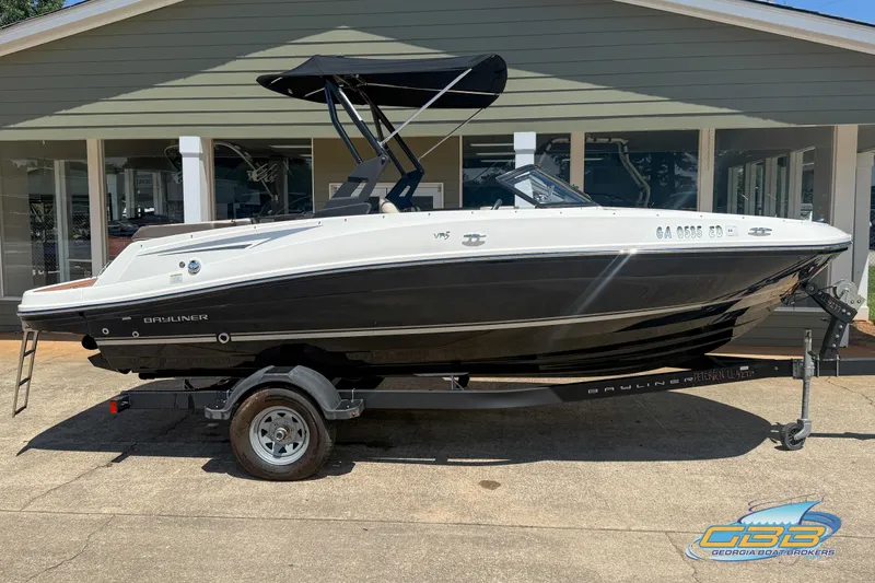 Slide: The Image of 2018 Bayliner VR5 Bowrider I/O boat on trailer, parked outside a building. - 3