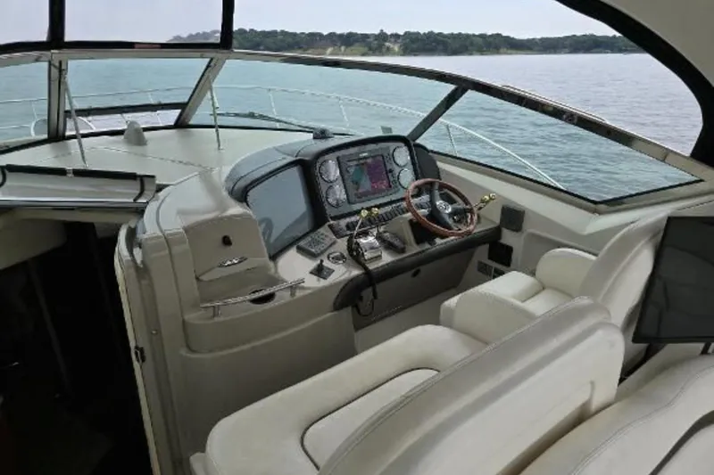 Slide: The Image of 2006 Sea Ray 380 Sundancer helm with modern navigation equipment and luxurious seating. - 12