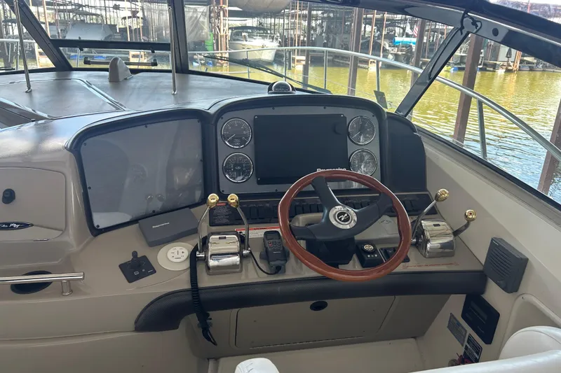 Slide: The Image of 2006 Sea Ray 380 Sundancer helm with wooden steering wheel and control panel. - 18