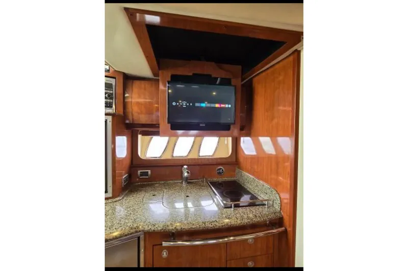 Slide: The Image of Luxurious 2006 Sea Ray 380 Sundancer yacht interior with modern kitchen and TV. - 9