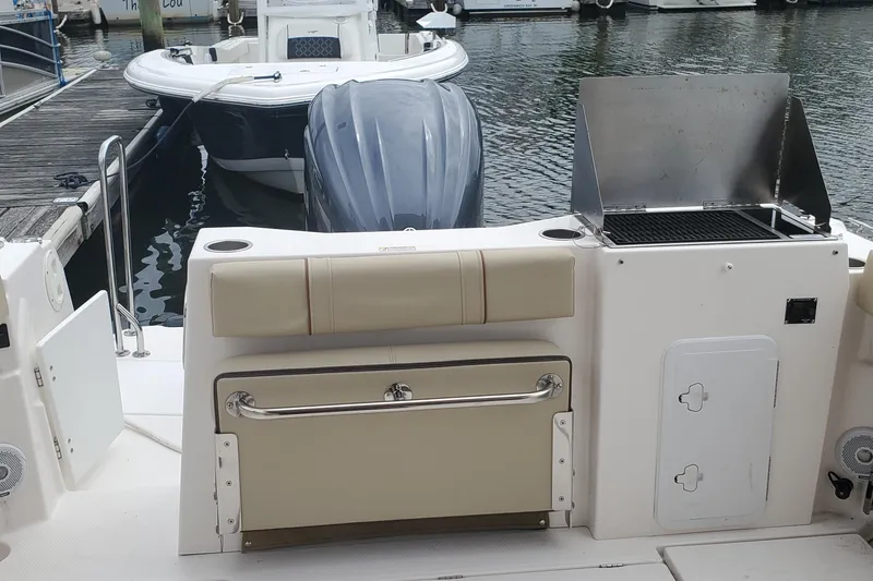 Slide: The Image of 2021 Ranger Tugs R-25 boat with outdoor grill and seating at marina. - 11