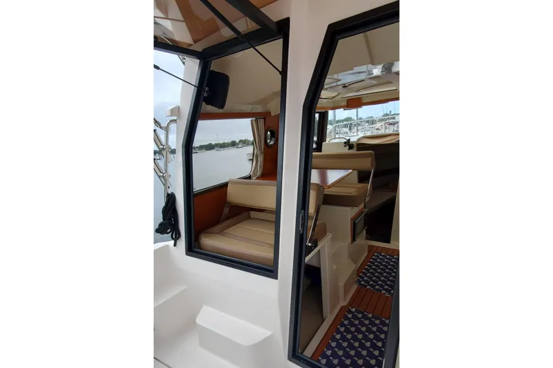 Slide: The Image of Interior view of 2021 Ranger Tugs R-25 boat, showcasing seating and cabin area. - 13