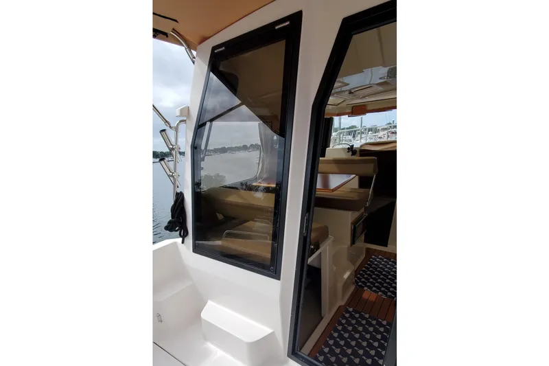Slide: The Image of 2021 Ranger Tugs R-25 boat interior view with open door and seating area. - 14