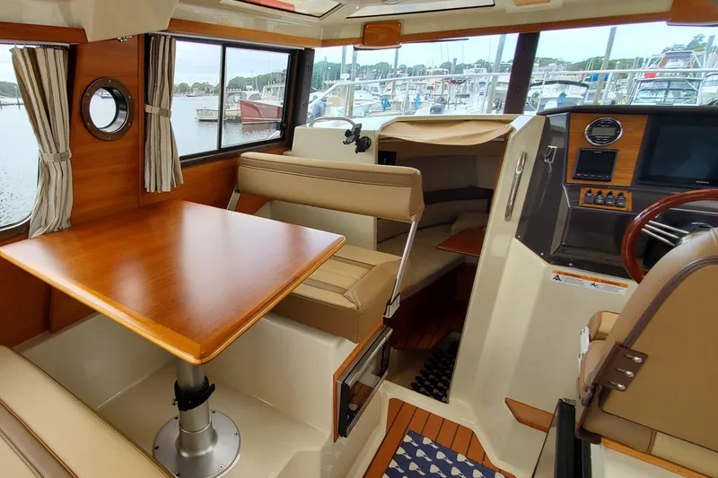Slide: The Image of Interior of 2021 Ranger Tugs R-25 boat with wood accents and seating area. - 17