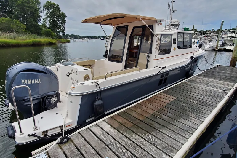 Slide: The Image of 2021 Ranger Tugs R-25 boat docked, featuring Yamaha outboard motor. - 4