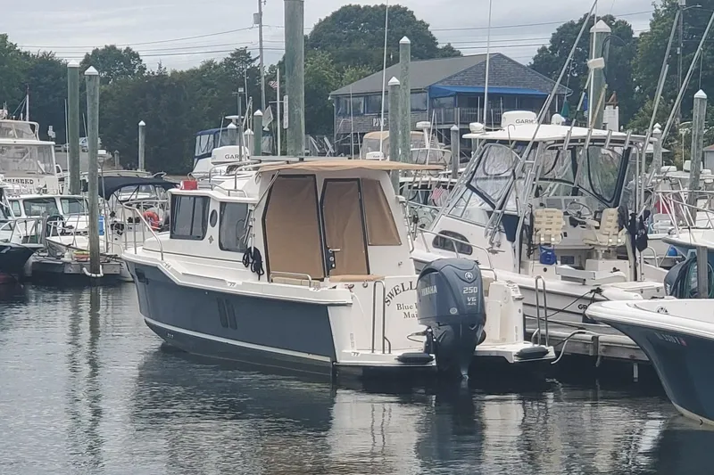 Slide: The Image of 2021 Ranger Tugs R-25 boat docked at a marina with other vessels. - 6