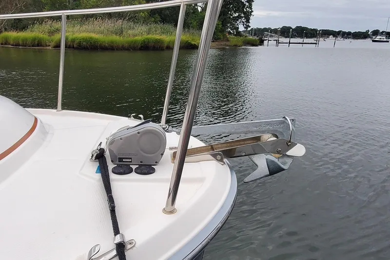 Slide: The Image of 2021 Ranger Tugs R-25 boat anchor system on calm water, near lush shoreline. - 9