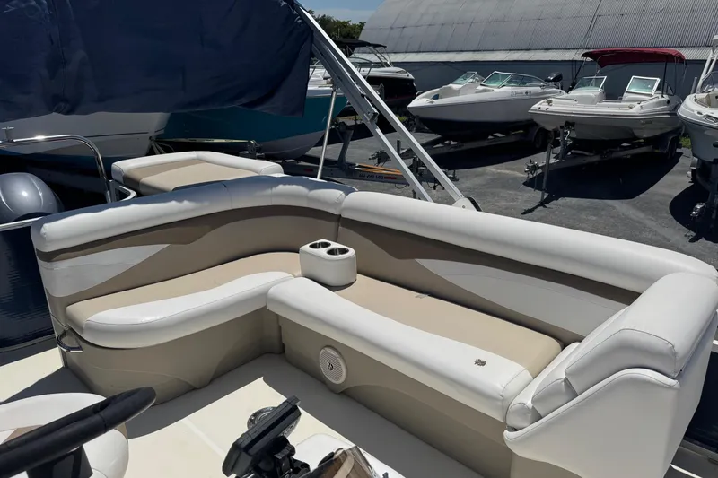 Slide: The Image of 2013 SouthWind 229 L boat interior with beige and white seating, docked among other boats. - 12
