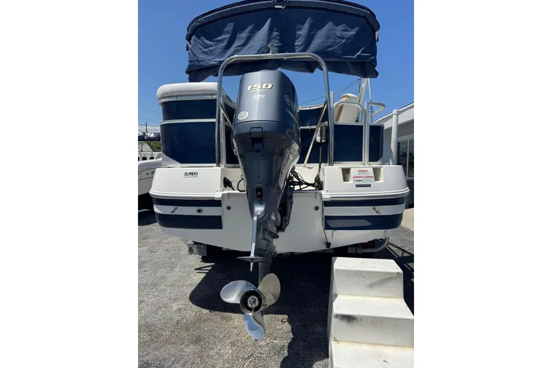 Slide: The Image of 2013 SouthWind 229 L boat with Yamaha 150 outboard motor, blue canopy, and rear view. - 24