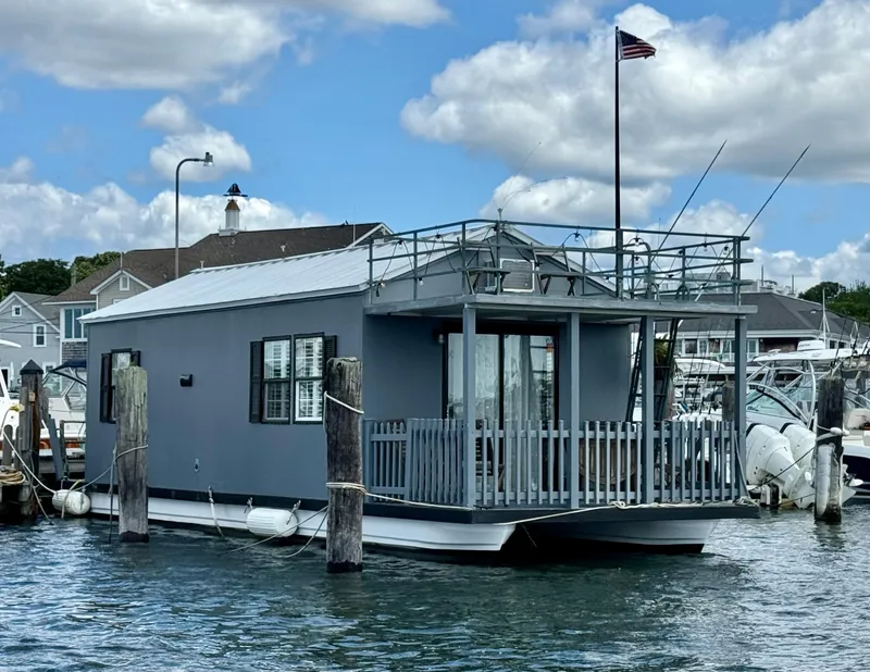 The Image of 2009 Catamaran Cruisers Aqua Lodge houseboat docked in marina, under blue sky with clouds. - 0