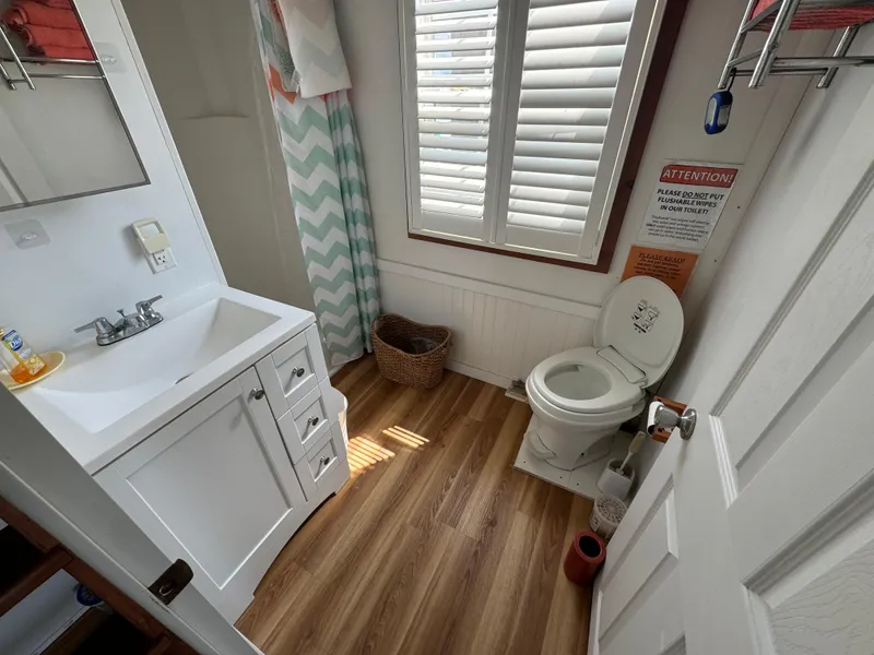 Slide: The Image of Bathroom interior of 2009 Catamaran Cruisers Aqua Lodge with sink, toilet, and window shutters. - 13