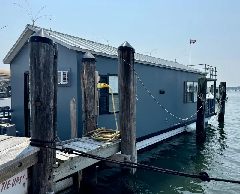 Slide: The Image of 2009 Catamaran Cruisers Aqua Lodge houseboat docked at marina, featuring a gray exterior. - 3