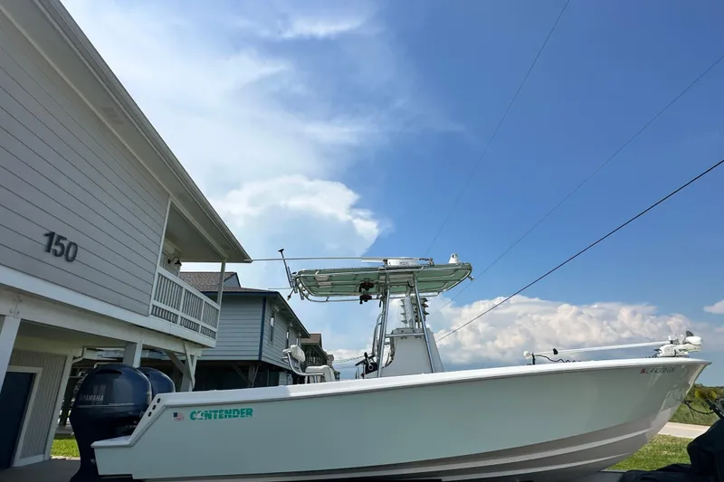 Slide: The Image of 2013 Contender 25 Tournament boat parked beside a house under a clear blue sky. - 10