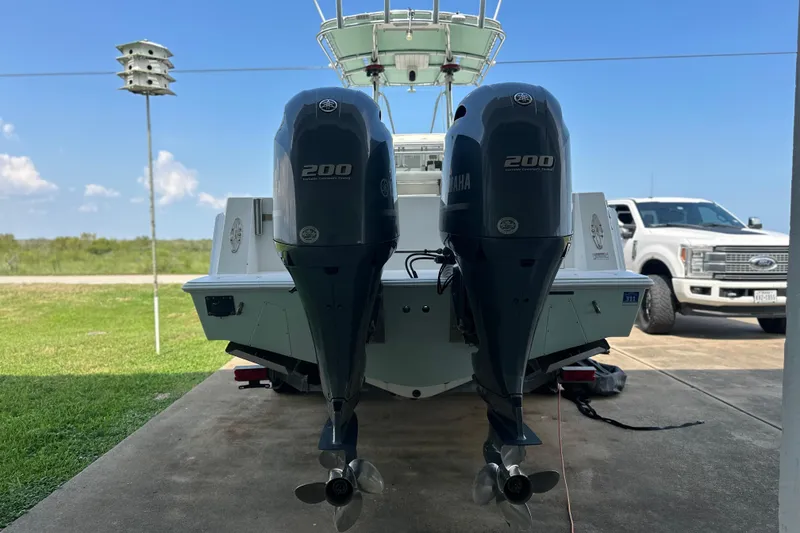 Slide: The Image of 2013 Contender 25 Tournament boat with dual Yamaha 200 engines, parked on a driveway. - 14