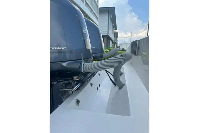 Slide: The Image of 2013 Contender 25 Tournament boat with dual outboard motors and visible hoses. - 21