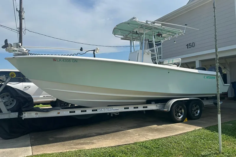 Slide: The Image of 2013 Contender 25 Tournament boat on trailer, parked in driveway. - 3