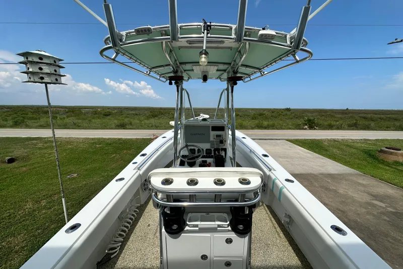 Slide: The Image of 2013 Contender 25 Tournament boat with center console and T-top, parked on a driveway. - 33
