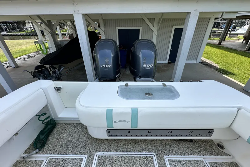 Slide: The Image of 2013 Contender 25 Tournament boat with dual 200 horsepower engines, docked under a shelter. - 40