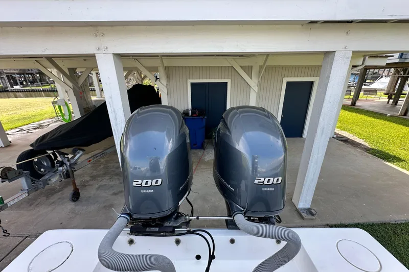 Slide: The Image of Twin Yamaha 200 engines on a 2013 Contender 25 Tournament boat, docked under a shelter. - 41