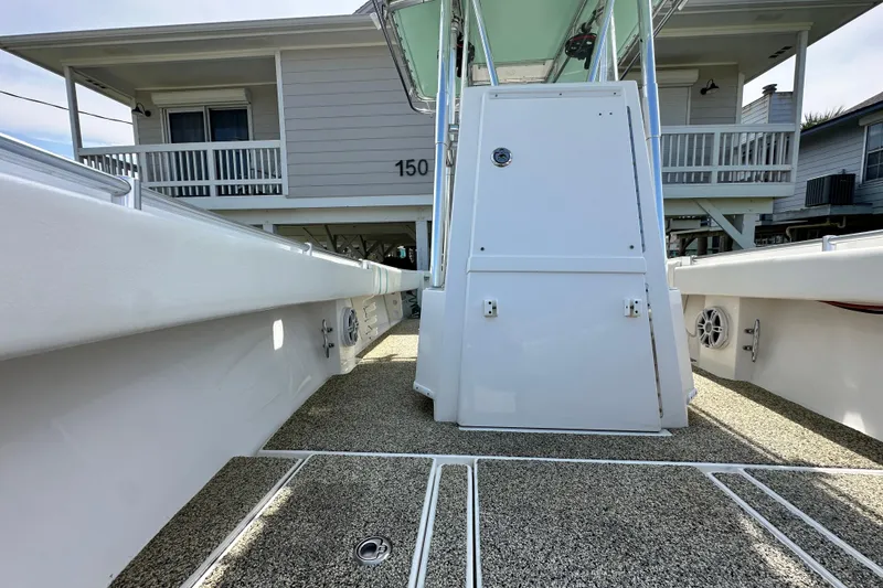 Slide: The Image of 2013 Contender 25 Tournament boat interior with clean deck and console, docked near a house. - 47