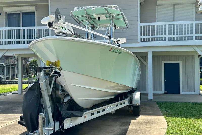 Slide: The Image of 2013 Contender 25 Tournament boat on trailer, parked near a house. - 7