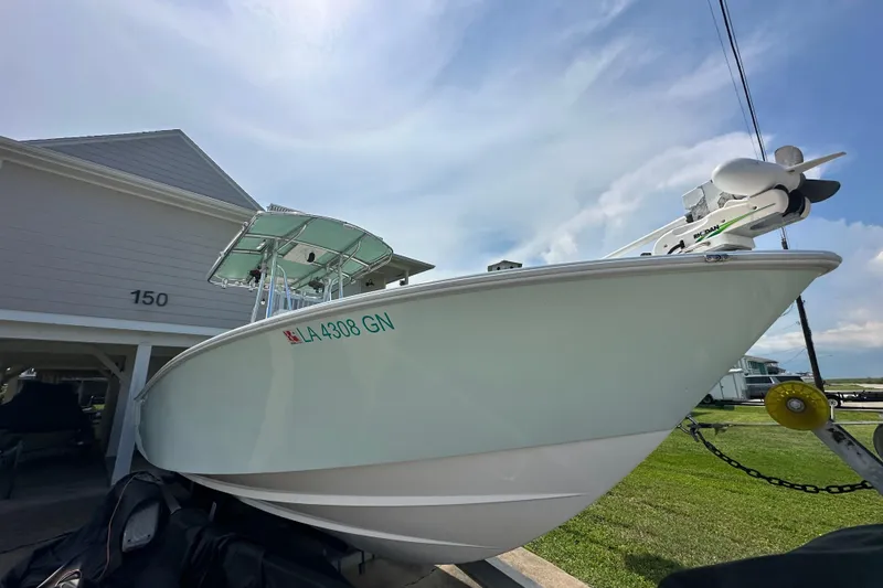 Slide: The Image of 2013 Contender 25 Tournament boat parked near a house, under a clear sky. - 9