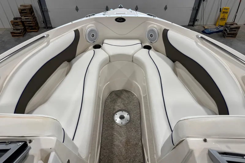 Slide: The Image of 2006 Rinker 246 boat interior with white cushioned seating and carpeted floor. - 15